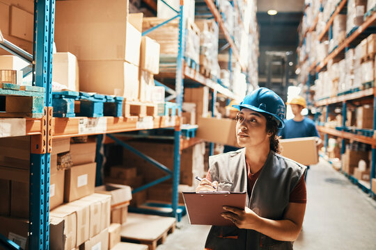 Young woman taking notes in warehouse