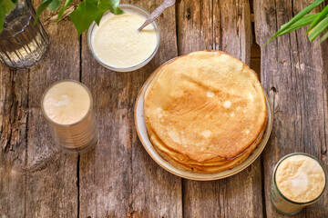 crepes with mascarpone sauce and condensed milk. Top view. Wooden background.