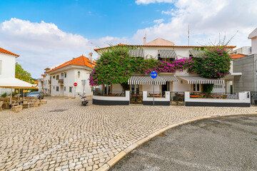 A picturesque neighborhood of bougainvillea fronted sidewalk cafes and shops in the historic old...