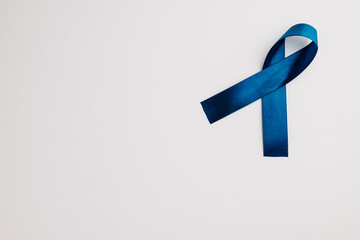 On a white background, a blue ribbon shines as a symbol of world diabetes day on November 14. Copy space available for your messages of support.