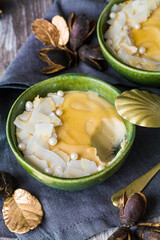 Petit bol de crème végétalienne avec des copeaux de noix de coco