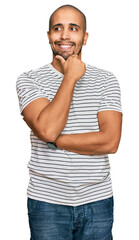 Hispanic adult man wearing casual clothes with hand on chin thinking about question, pensive expression. smiling with thoughtful face. doubt concept.