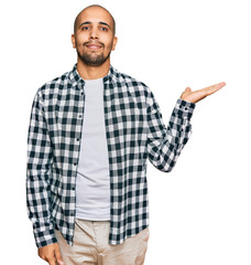 Fototapeta premium Hispanic adult man wearing casual clothes smiling cheerful presenting and pointing with palm of hand looking at the camera.