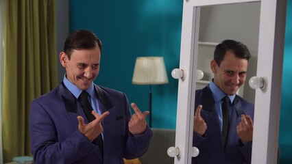 A man in a strict suit is standing in the living room in front of a mirror close up. Split...