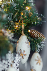 Christmas background with pine branch and beautiful colored shiny bokeh. Wool pine cones. New Years. Shallow depth of field.