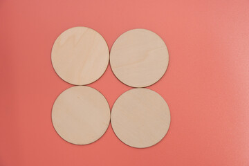 Wooden disks on a pink background with room for copy or graphics. Three disks arranged in a rough diagonal moving up from left to right.