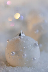 Christmas beautiful gray blurred background with white balls with pearls and colored bokeh. Shallow depth of field
