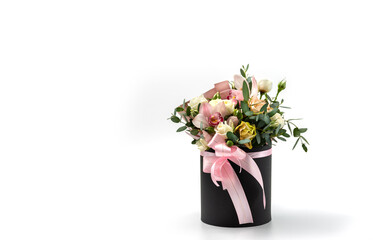 Flower arrangement in a hat box, a pot of roses and orchids on a white background