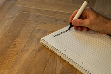 Blank notepad in class on wooden desk for student learning Ukrainian written language. communication subject for adult learning with handwritten notes and writing exercises for personal development