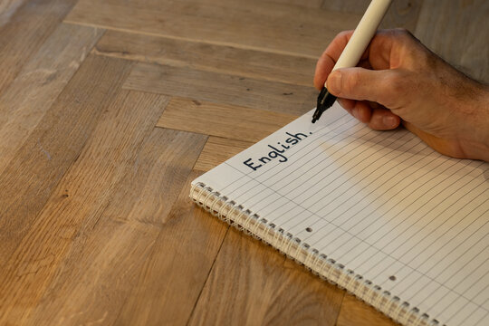 Blank notepad in class on wooden desk for student learning English written language. Language subject for adult learning with handwritten notes and writing exercises for personal development