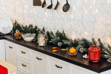 Cozy flat apartment photo studio room kitchen utensils gifts presents garlands, candles decorated toys balls interior New Year lights glowing bokeh
