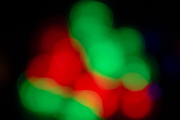 Double exposure Christmas lights, red and green. Abstract, blurred and centered on a black background. 