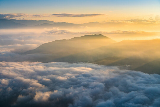 Aerial view of low clouds over mountains at sunset in Yunnan province, China.