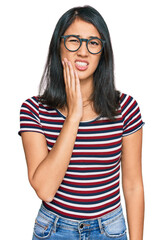 Beautiful asian young woman wearing casual clothes and glasses touching mouth with hand with painful expression because of toothache or dental illness on teeth. dentist