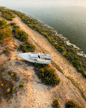 Aerial view of a wooden boat stranded on the beach of Cap Ferret, Nouvelle-Aquitaine, France.
