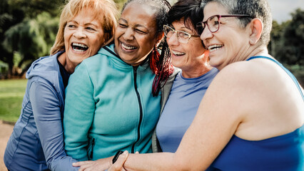 Group of senior women after sport exercise workout hugging outdoors at Park City. Elderly community...