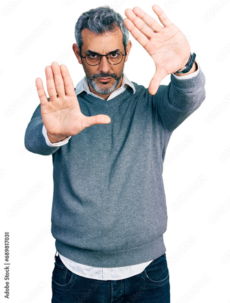 Wall mural Middle age hispanic with grey hair wearing glasses doing frame using hands palms and fingers, camera perspective