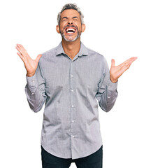 Middle age grey-haired man wearing casual clothes celebrating mad and crazy for success with arms...