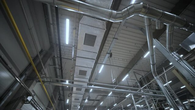 HVAC Duct Cleaning, Ventilation pipes in silver insulation material hanging from the ceiling inside new building.