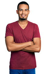 Fototapeta premium Young african american man wearing casual t shirt happy face smiling with crossed arms looking at the camera. positive person.