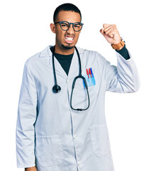 Fototapeta premium Young african american man wearing doctor uniform and stethoscope angry and mad raising fist frustrated and furious while shouting with anger. rage and aggressive concept.