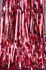 Pink party streamers background, party decoration with pink shiny tinsel strings
