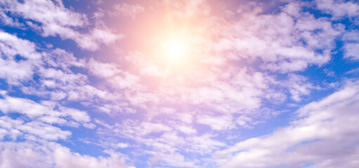 Light clouds and sun in the blue sky. Wide photo.