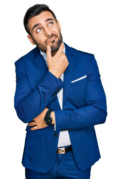 Young hispanic man wearing business jacket thinking worried about a question, concerned and nervous with hand on chin