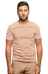 Fototapeta premium Handsome hispanic man wearing casual clothes relaxed with serious expression on face. simple and natural looking at the camera.