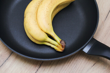 Bananas on frying pan. Bunch of bananas. Conceptual background of frying bananas. Unpeeled bananas....