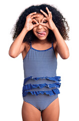 African american child with curly hair wearing swimwear doing ok gesture like binoculars sticking...
