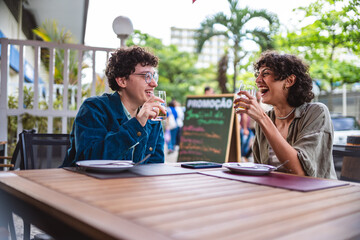 Casal de mulheres bebendo e se divertindo durante agradavel almoco em um restaurante ao ar livre.