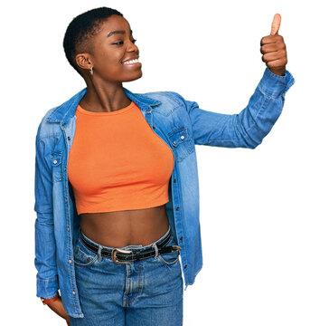 Young african american woman wearing casual clothes looking proud, smiling doing thumbs up gesture to the side