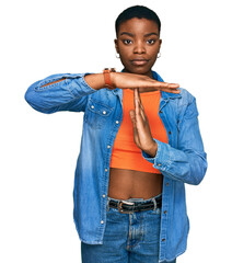 Young african american woman wearing casual clothes doing time out gesture with hands, frustrated...