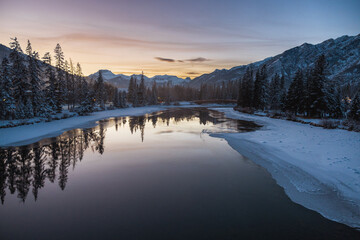 Wintry landscape of mountains and river in Banff at dusk