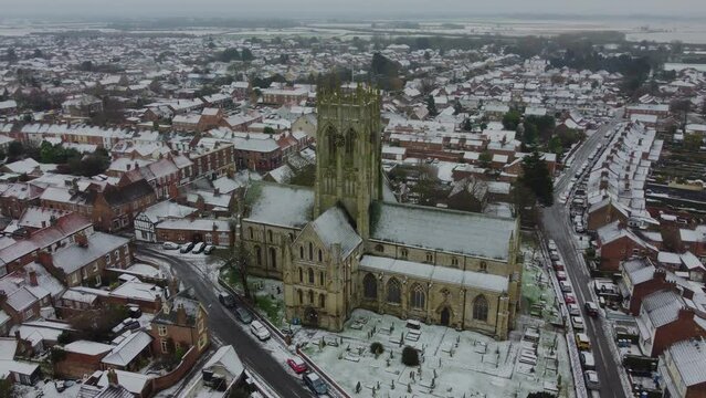 Rotating Drone shot. Snow winter scene. Church of England. Parish church in English countryside. Christian church worship UK. 