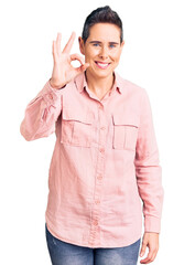 Young woman with short hair wearing casual clothes smiling positive doing ok sign with hand and fingers. successful expression.