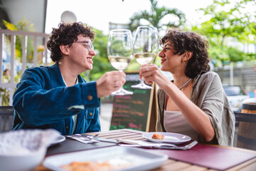 Girlfriends toasting in an open-air restaurant.