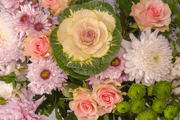 Bouquet of flowers with pink roses, brassica flower, chrysanthemum and freesia flower in a vase.
