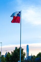 La bandera de Chile flameando con la ciudad De Santiago de fondo en el atardecer. Tomada en la comuna de Vitacura. 