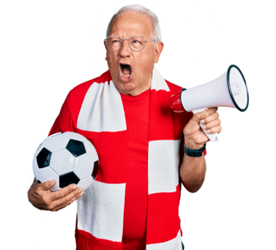 Senior man with grey hair football hooligan holding ball and using megaphone angry and mad screaming frustrated and furious, shouting with anger. rage and aggressive concept.