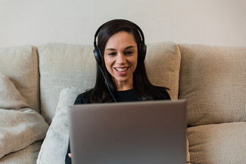 Cheerful woman chatting using laptop