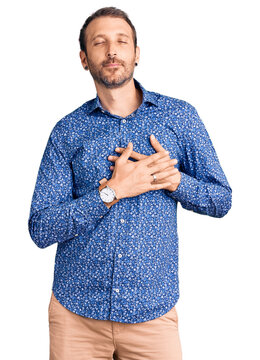 Young handsome man wearing casual clothes smiling with hands on chest with closed eyes and grateful gesture on face. health concept.