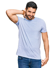 Fototapeta premium Young hispanic man wearing casual clothes suffering of neck ache injury, touching neck with hand, muscular pain