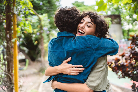 Happy meeting of two friends hugging in the park.