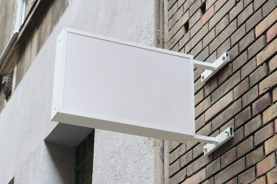 Street storefront shop, cafe, restaurant mounted signboard mock up design template. Blank white store sign design mockup.