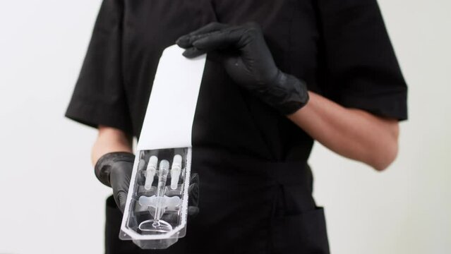 Сosmetologist esthetician unpacking new syringe for injection. Doctor doing injection with botox for rejuvenation face skin. Lip augmentation procedure. Beauty injections. Plastic surgery. 