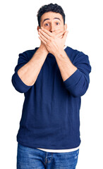Young hispanic man wearing casual clothes shocked covering mouth with hands for mistake. secret...