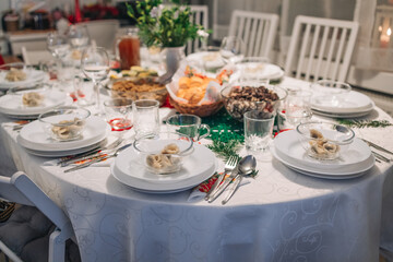 Polish Wigilia. Christmas Eve red borscht soup with mushroom filled ravioli and beet chips and sauerkraut with mushrooms on festive table. High quality photo