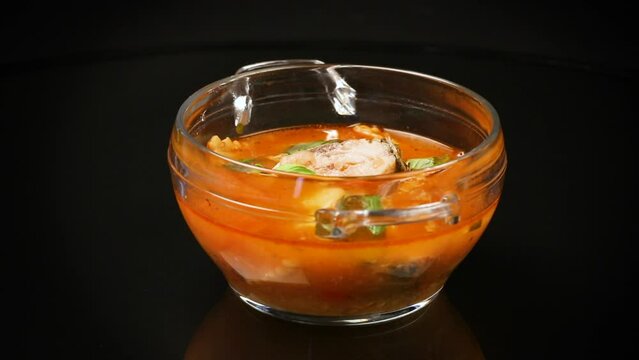 vegetable tomato soup with fish in a plate